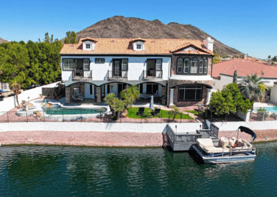 A house with a pool and a boat on the water.